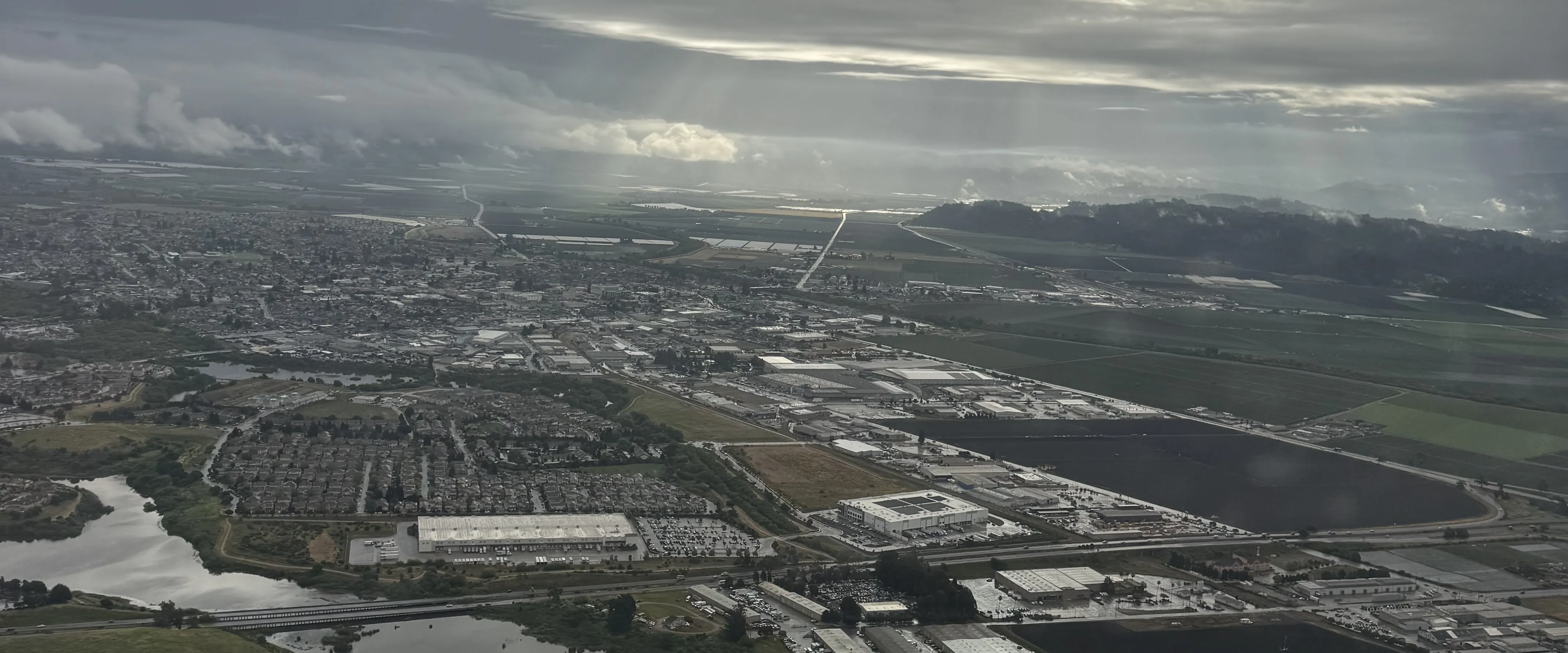Aerial view of an industrial waterfront beneath dramatic clouds